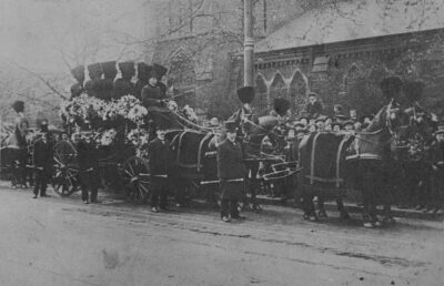 T Cribb & Sons 殯儀師手持權仗帶領送葬隊伍。T Cribb & Sons Procession carrying Funeral Truncheons c. 1900 （Credit：National Funeral Museum Collection 倫敦國家葬禮博物館收藏 ）